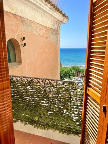 a view of a building with a green hedge at Florenza Residence in Sperlonga