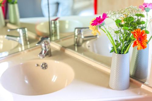 um lavatório de casa de banho com um vaso com flores em Metro Inns Newcastle em Newcastle upon Tyne