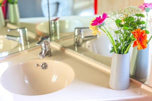 a bathroom sink with a vase with flowers in it at Metro Inns Newcastle in Newcastle upon Tyne