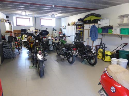 a garage with a bunch of motorcycles parked in it at Hotel De Franc Bois in Chimay