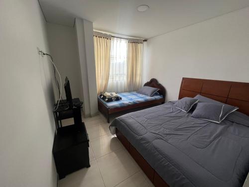 a bedroom with a bed and a television in it at Hotel Playa Blanca in Tota
