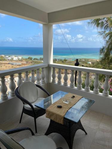 a table and chairs on a balcony with a view of the ocean at L'Heritage - Vue sur mer in Rodrigues Island