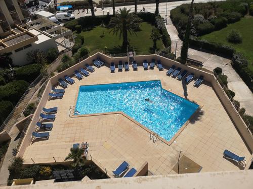 - une vue sur la grande piscine avec des chaises longues dans l'établissement 20 m2 de terrasse face à la mer à Canet en Roussillon, à Canet