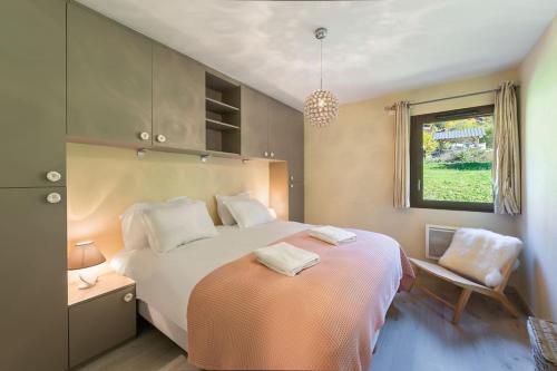 een slaapkamer met een groot wit bed en een raam bij Les 4 Elements - Apt A11 - BO Immobilier in Châtel