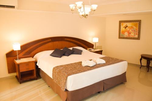 a bedroom with a large bed with two towels on it at Hotel Golden Park Internacional Foz & Convenções By Nacional Inn in Foz do Iguaçu