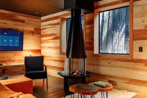 a living room with a fireplace in a log cabin at Ort Hotel in Campos do Jordão