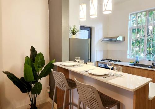 a kitchen with a island with chairs and a counter top at The Beach Life Pereybere in Pereybere