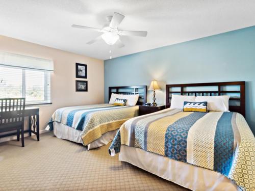 sypialnia z 2 łóżkami i wentylatorem sufitowym w obiekcie Yacht Club Villas #2-405 condo w mieście Myrtle Beach