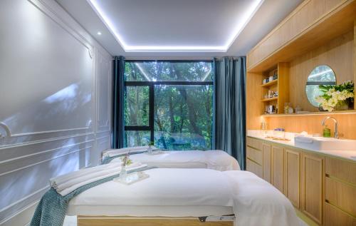 dwa łóżka w pokoju z oknem w obiekcie L'Orangerie du Château des Reynats w mieście Chancelade