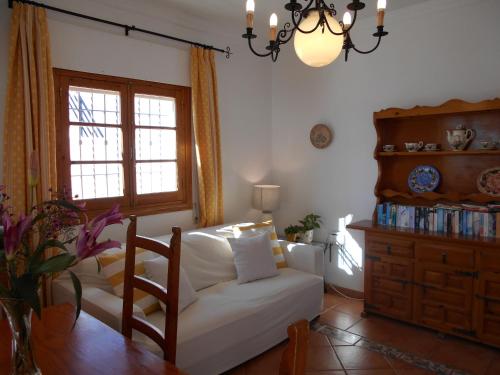 Una sala de estar con un sofá blanco y una ventana. en Penthouse Sleeps 4 with Private Garden, en Chipiona