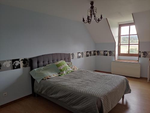 ein Schlafzimmer mit einem Bett in einem weißen Zimmer in der Unterkunft Gîte de la Forêt in Saint-Jeanvrin