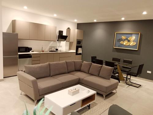 a living room with a couch and a kitchen at Waypoint Suites in Dakar
