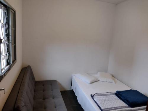 a small room with a bed and a couch at Casa Cogumelo Azul in São Thomé das Letras