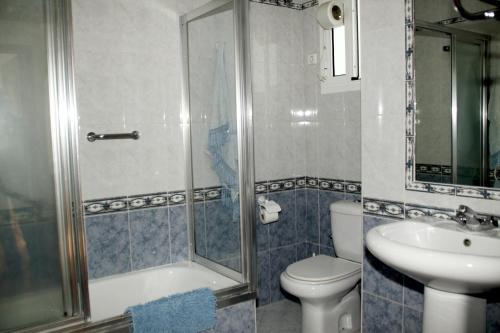Un baño con ducha, inodoro y lavabo. en Penthouse Sleeps 4 with Private Garden, en Chipiona