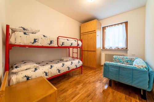 1 dormitorio con 2 literas y 1 silla en Appartamento Dolomia, en Caprile