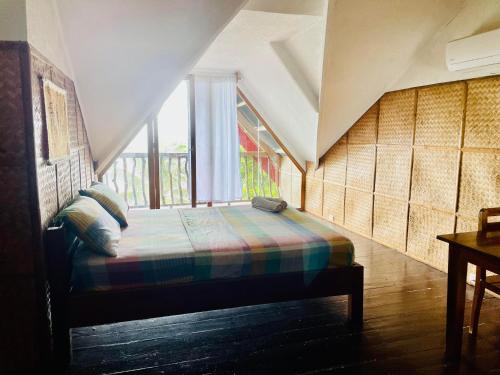 a bedroom with a bed in a room with a window at White Beach Front and Cottages in Buruanga