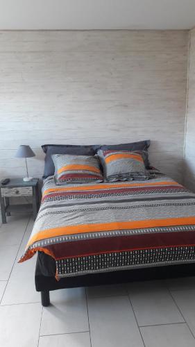 una cama con varias almohadas en una habitación en STUDIO PROCHE DE LA MER en Agon Coutainville