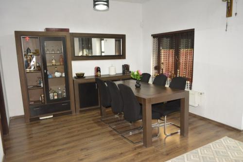 a dining room with a wooden table and black chairs at Camere Centrale in Piteşti