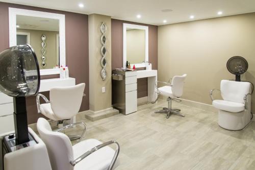 a hair salon with white chairs and a mirror at Bougainvillea Barbados in Christ Church