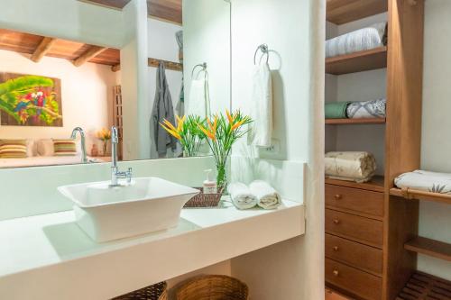 een badkamer met een wastafel en een spiegel bij Casa Caminho do Mar (TRANCOSO-BA) in Trancoso