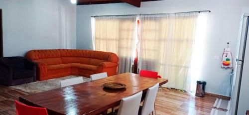 sala de estar con mesa de madera y sofá en Incrivel chacara com pisc e churrasq em Extrema MG en Extrema