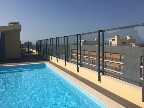 a balcony with a swimming pool on top of a building at FLORIPES LUXURY APARTMENT with Pool on Rooftop in Olhão