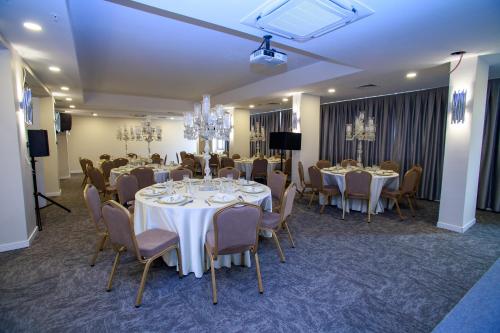uma sala de jantar com mesas e cadeiras e uma sala com lustres em Mitte Port Hotel Konak Izmir em Esmirna