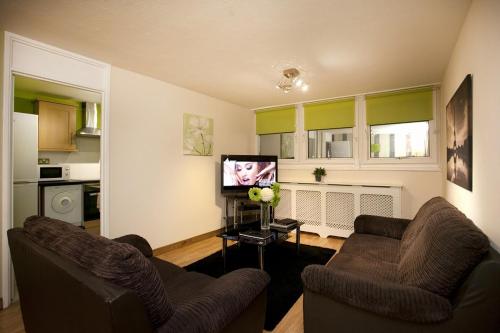 a living room with two chairs and a flat screen tv at Victoria Centre Apartments in the Victoria Centre Shopping Centre - Nottingham City Centre - 24 hour access - Most Central Location - Full Kitchen - Opposite Hilton - Parking for Cars or Vans from Five pounds a day - Sunday 1pm Check-out - in Nottingham