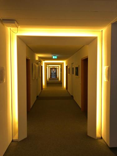 an empty hallway in an office building with lights at Spectrum Kirche Exerzitien-und Bildungshaus auf Mariahilf in Passau