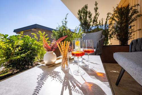 a table with two glasses of wine on a balcony at FESH LIVING in Kaprun