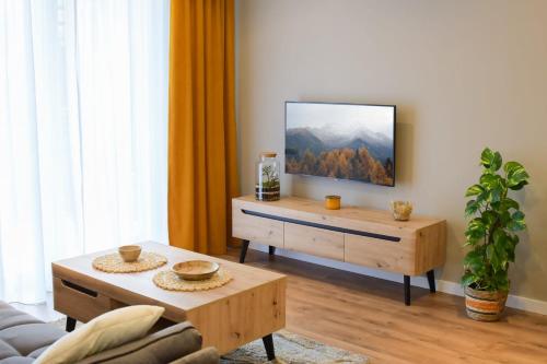 een woonkamer met een flatscreen-tv aan de muur bij Apartament 3B in Przemyśl