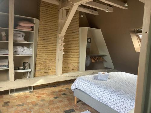 a bedroom with a bed and a brick wall at Les Chambres du Roi in La Flèche