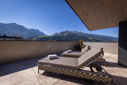 a bed on a balcony with mountains in the background at FESH LIVING in Kaprun