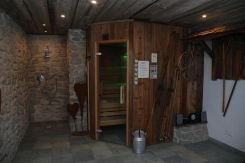 a room with a shower with a wooden door at Kuschelhüsli Ganahl Wohnung Zamangspitze in Aussersiggam