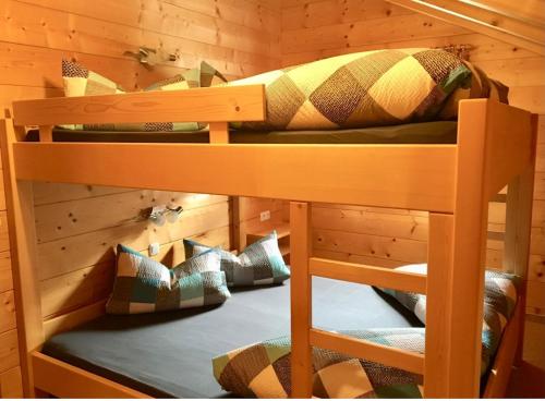 two bunk beds in a wooden room with pillows at Kuschelhüsli Ganahl Wohnung Zamangspitze in Aussersiggam
