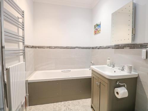 a bathroom with a bath tub and a sink at Robin's Nest in Brisley