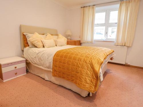 a bedroom with a large bed and a window at Bronte Cottage in Keighley