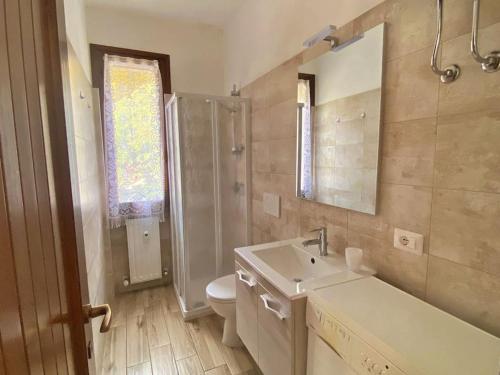 uma casa de banho com um lavatório, um WC e um espelho. em [FREE WIFI] Elegante bilocale vicino alle piste em Scopello