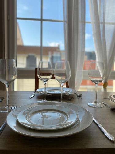 - une table avec une assiette et des verres à vin dans l'établissement Appart - centre-ville - 4 PERS -PROCHE plage, à Fort-Mahon-Plage