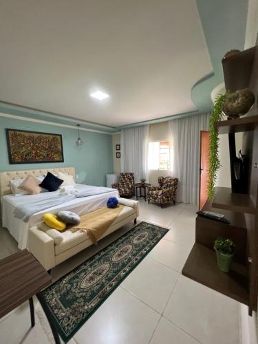 a bedroom with a bed and a living room at Pousada Vista da Pedra in Itamaraju
