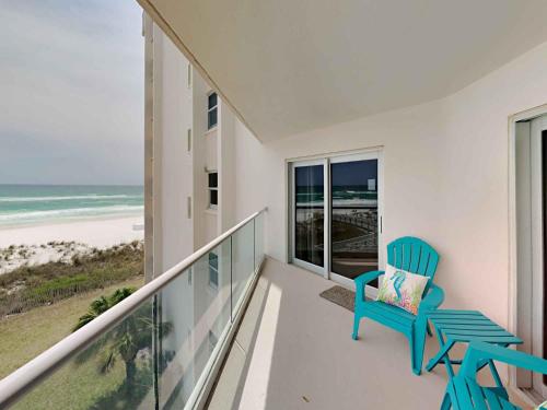 a balcony with a blue chair and a view of the beach at Regency Towers #403 West in Pensacola Beach