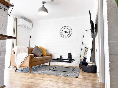 a living room with a couch and a table at Manhattan - Stylish 1BR Beachfront on Caseys in Batehaven