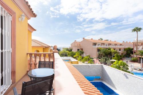 a balcony with a table and chairs and a swimming pool at LUXURY VILLA WITH PRIVATE POOL WITH AIRCON,Playa del Duque in Adeje