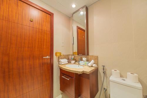 ein Badezimmer mit einem Waschbecken, einem WC und einem Spiegel in der Unterkunft WORLD CLASS 1BR with DUBAI DOWNTOWN BOULEVARD view in Dubai