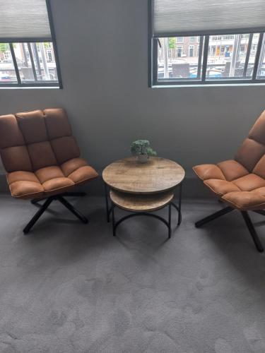 two chairs and a table in a room with a table at Boutique Hotel De Oude Veste in Hellevoetsluis