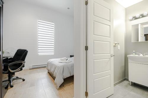 a bedroom with a bed and a desk and a chair at HoMa Homestay Hotel by Olympic Stadium Montreal Auberge-Hostel in Montréal