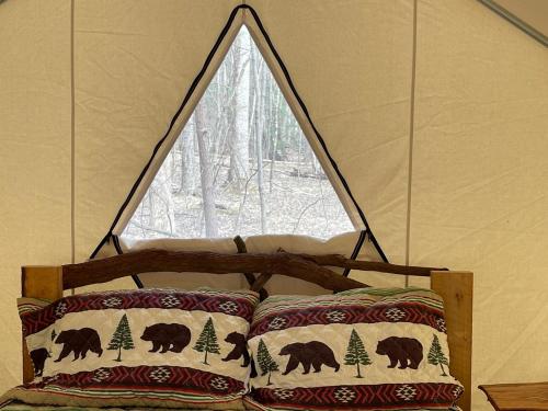 a bed in a tent with a window at Tentrr Signature Site - 6 Ponds Farm Glamping in Morganton