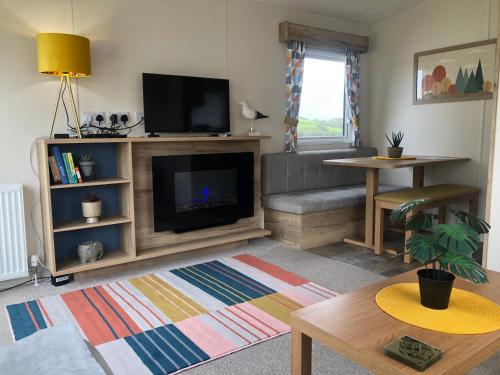 ein Wohnzimmer mit einem Flachbild-TV und einem Sofa in der Unterkunft Newquay Bay Resort - Summer Days 135 in Newquay Bay Resort