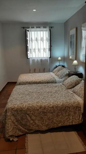 1 dormitorio con 2 camas y ventana en Ronda, en Ronda