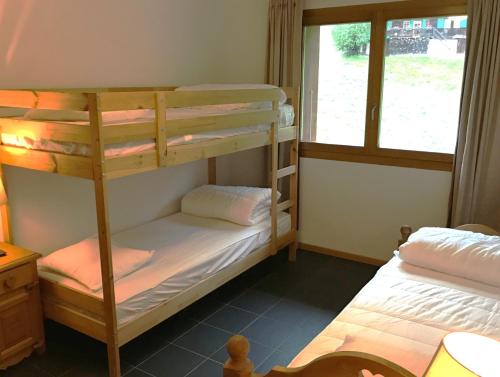 een slaapkamer met 2 stapelbedden en een raam bij Mountain River Luxury Apartment in Val dʼIlliez